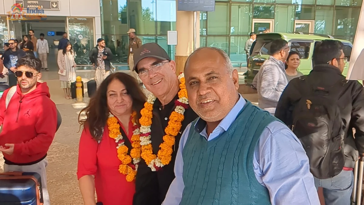 International tourists receiving a traditional marigold flower garland welcome at Jaipur Airport in Rajasthan