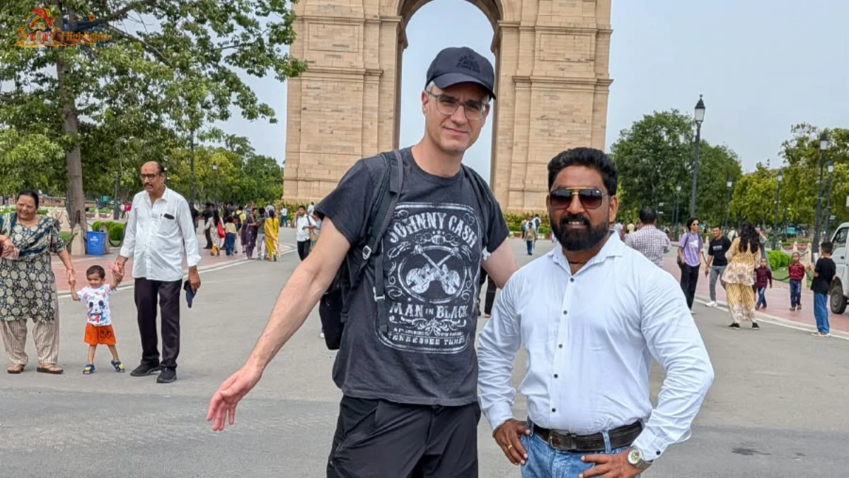 Traveler and India Highlights guide posing together in front of the monumental India Gate in New Delhi